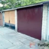 Wolnostojący garaż murowany na Mokotowie z zamkniętą brązową bramą stalową